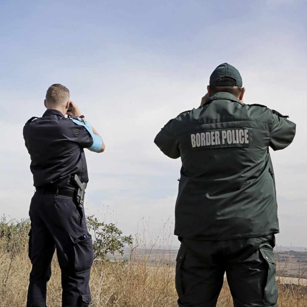 Two border policemen observe border